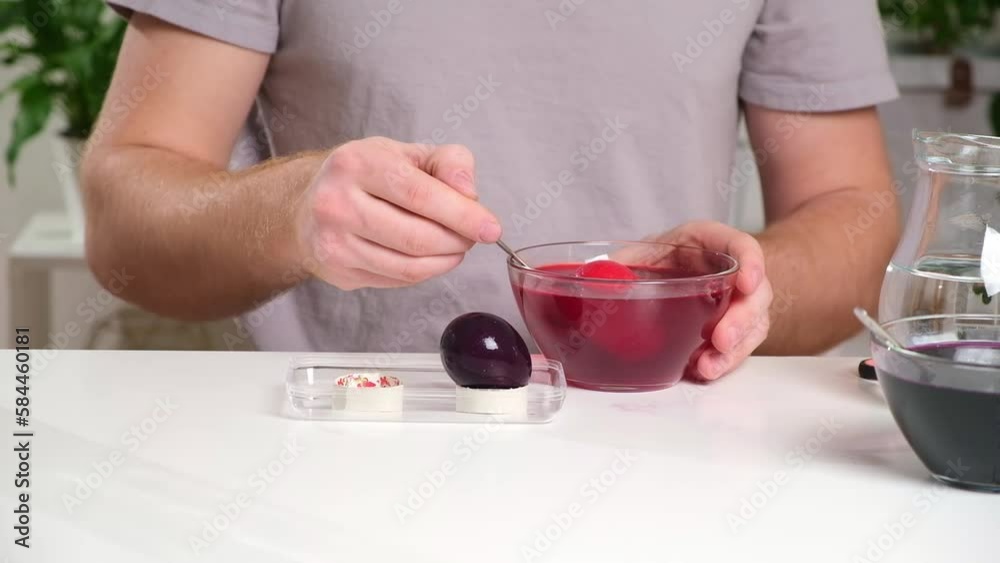 A man takes out colored Easter eggs from colored water. Dyeing easter eggs with food coloring is the first step in favorite Easter egg decorating ideas. A man takes out colored Easter eggs from colored water. Dyeing easter eggs with food coloring is the first step in favorite Easter egg decorating ideas.