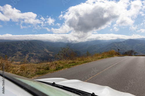 ocomotion, freedom, mobility showing through car on road with great view on a mountain range and the blue sky with clouds photo