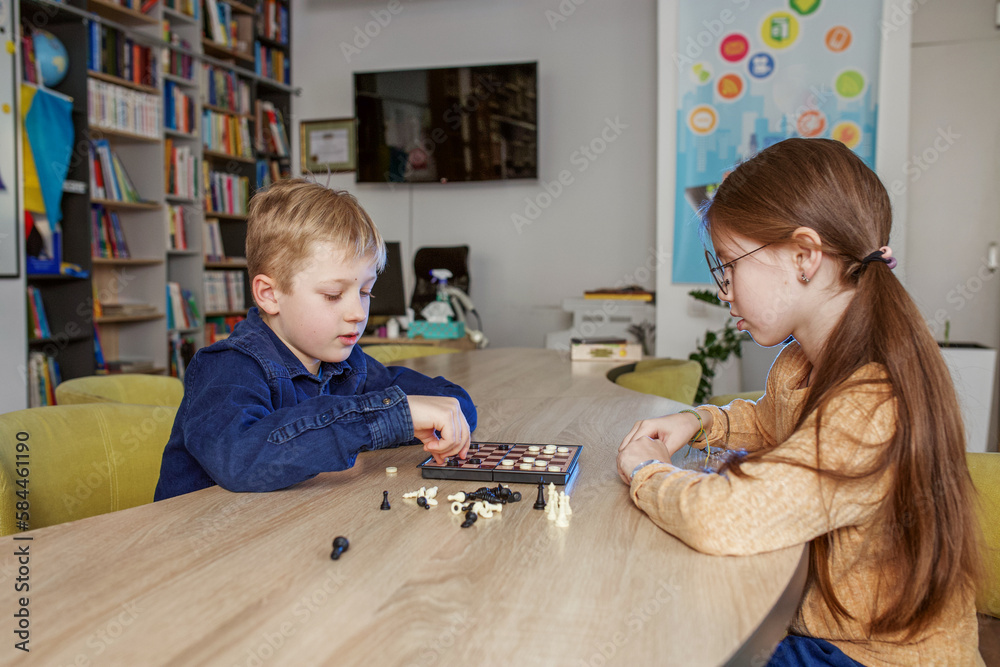 Children play game of checkers. Concept of education, hobby and leisure. Children play game of checkers. Concept of education, hobby and leisure.