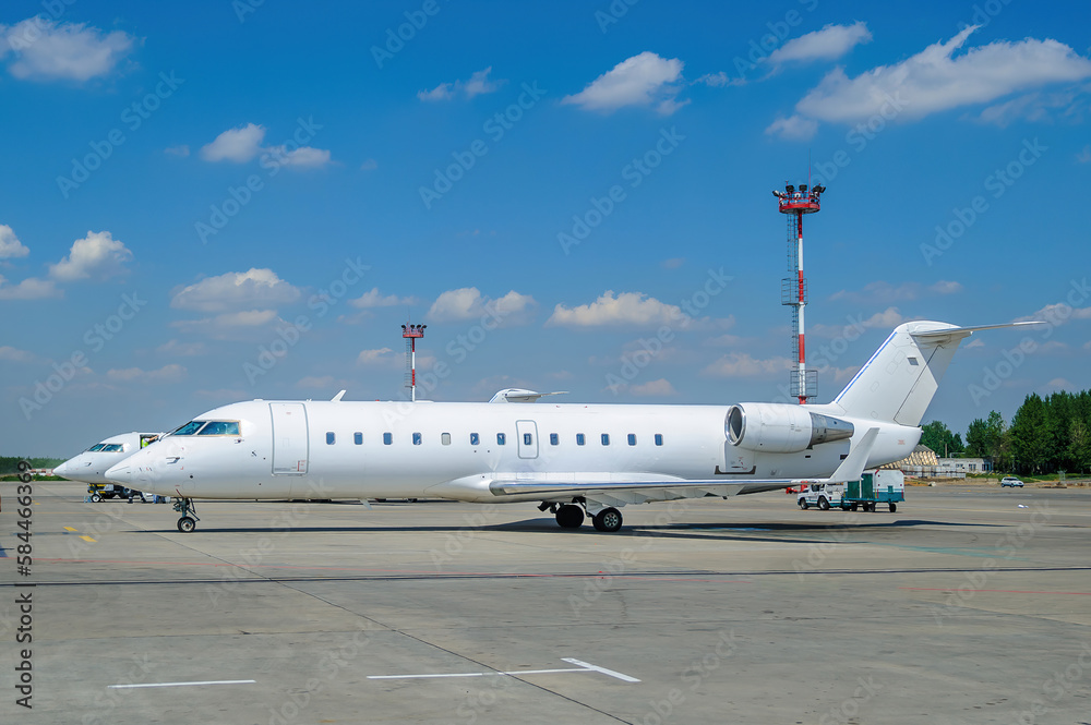 Obraz premium White passenger plane parked at the airport. Passenger aircraft, white aircraft without livery. Jet plane in the parking lot
