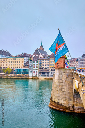 Flags on Mittlere Brucke and Old town district on background in Basel, Switzerland photo