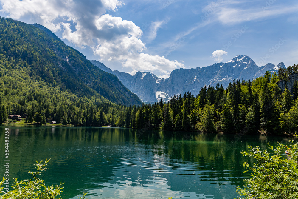 Alpine quiet mirror blue lake in the Italian Dolomites Lagi di Fusine