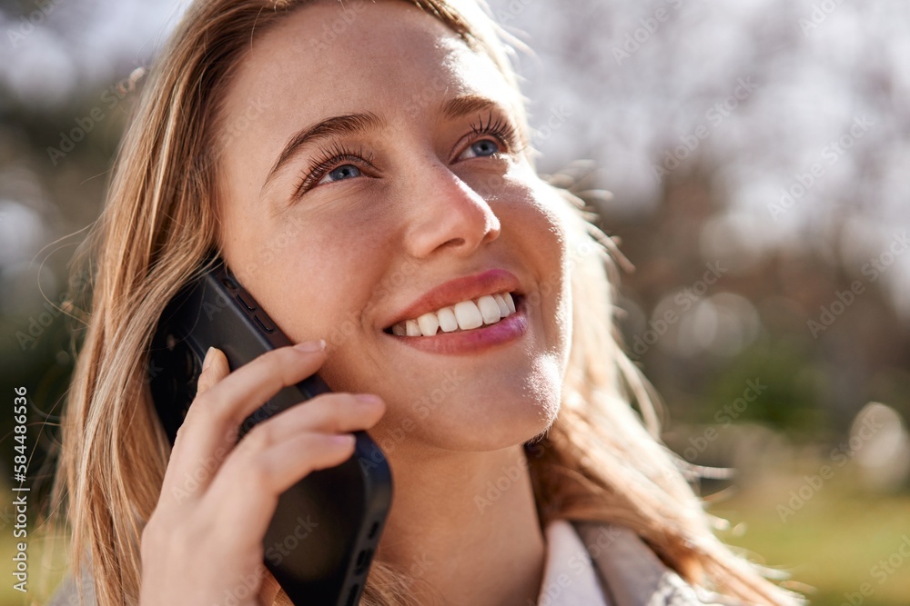 Joyful young Caucasian woman talking on phone Joyful young Caucasian woman talking on phone