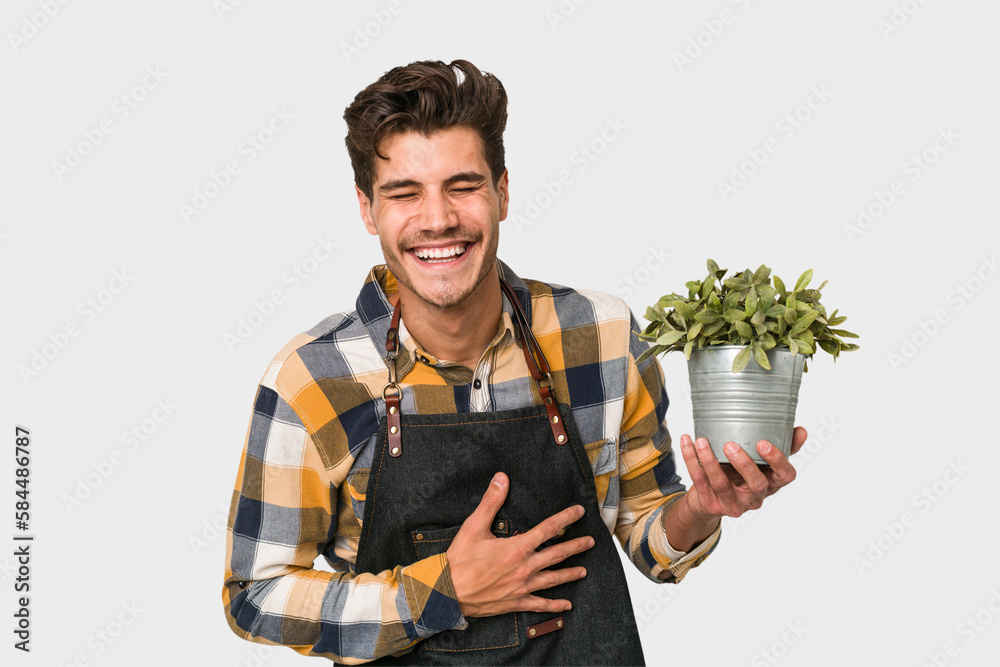 Young caucasian gardener man isolated on white background laughing and having fun.