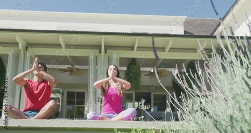 Wallpaper Mural Focused biracial couple practicing yoga and meditating in garden on sunny day Torontodigital.ca