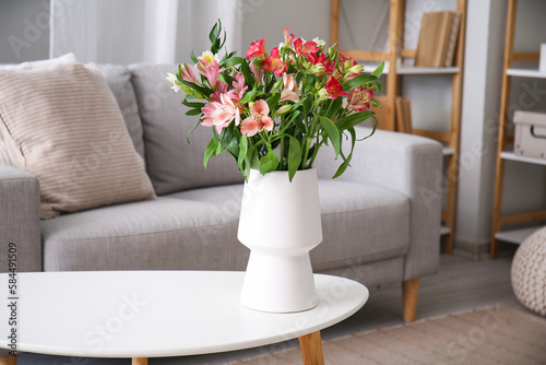 Vase with bouquet of beautiful alstroemeria flowers on table in living room