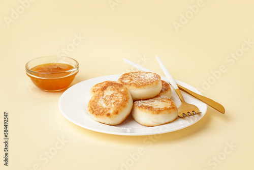 Plate of delicious cottage cheese pancakes and jam on color background