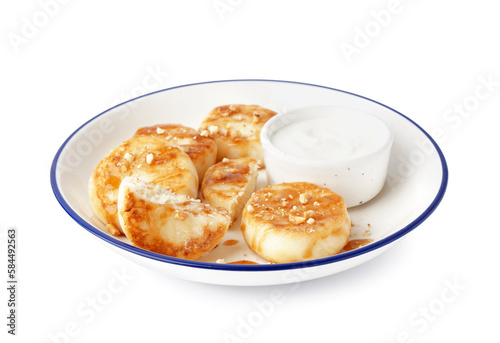Plate with tasty cottage cheese pancakes and sour cream isolated on white background