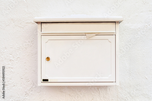 View of mailbox on white building wall