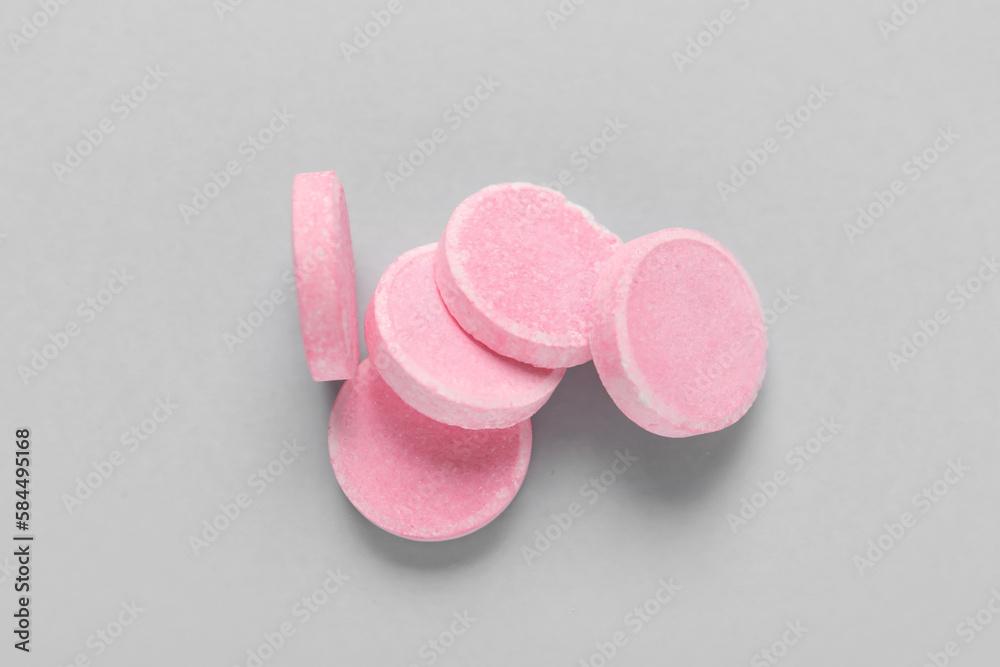 Pink soluble tablets on grey background Pink soluble tablets on grey background
