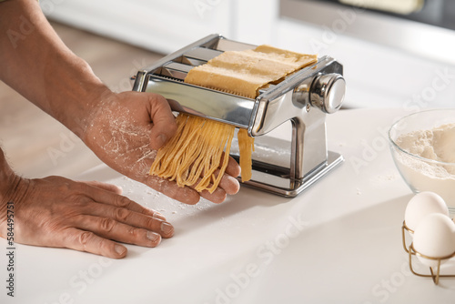 Man making pasta with machi...