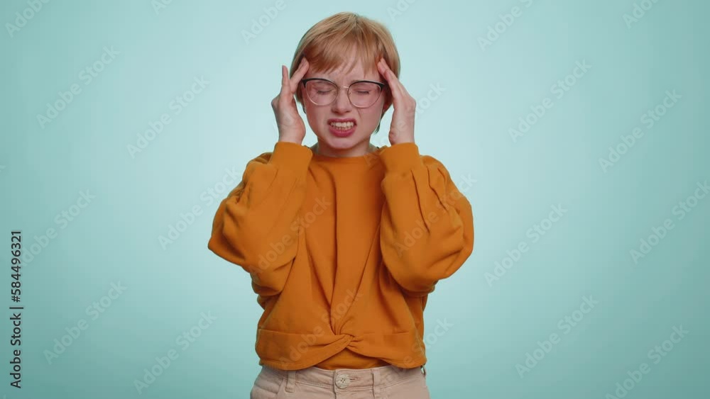 Pretty short haired woman in sweater rubbing temples to cure headache problem, suffering from tension, migaine, stress, grimacing in pain, high blood pressure isolated alone on blue wall background Pretty short haired woman in sweater rubbing temples to cure headache problem, suffering from tension, migaine, stress, grimacing in pain, high blood pressure isolated alone on blue wall background