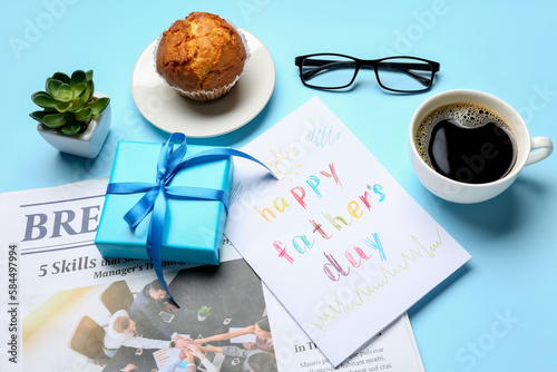 Composition with greeting card, gift, newspaper, cup of coffee and muffin on color background. Father's Day celebration