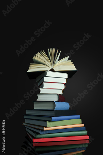 Stack of different hardcover books on black background