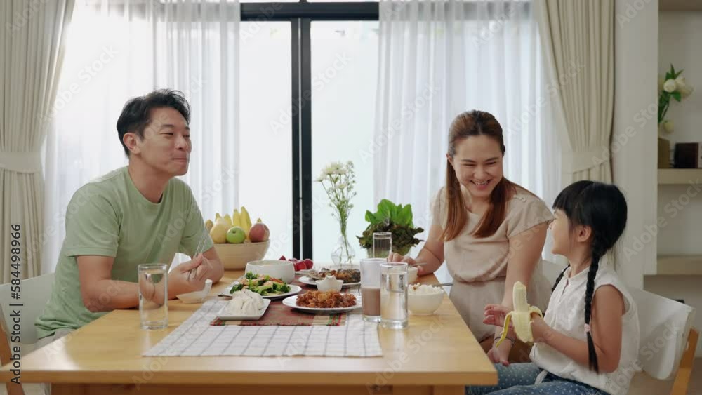 Asian family eating breakfast at the dining table inside the kitchen, family relationships
Asian family eating breakfast at the dining table inside the kitchen, family relationships