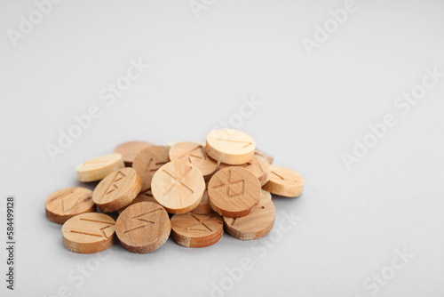 Pile of wooden runes on light grey background