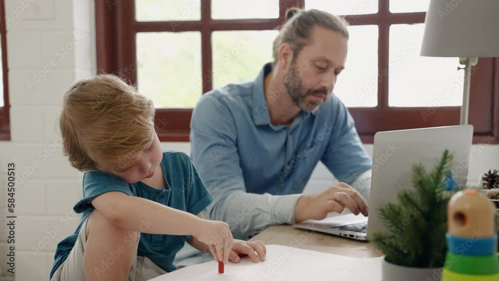 Father sitting at work using tablet while son drawing and painting, family relations concept
Father sitting at work using tablet while son drawing and painting, family relations concept
