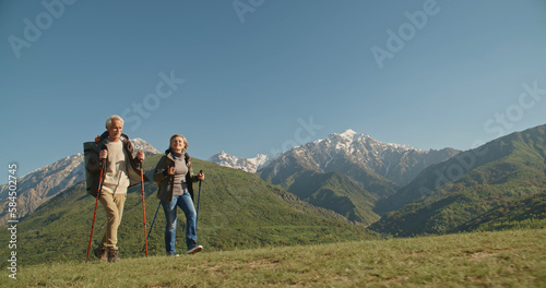 Mature caucasian couple on vacation, having a hike in spring mountains, spending time together after retirement together travelling - tourism, pension concept