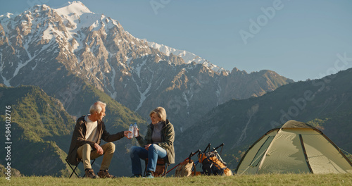 two happy active seniors together having fun at the top of the mountain in evening afternoon - couple of mature people enjoying and having fun in vacations - traveling and travelers lifestyle
