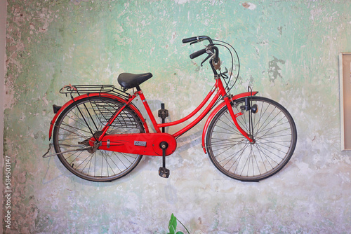 Red bicycle putting on the dirty and artisty wall photo