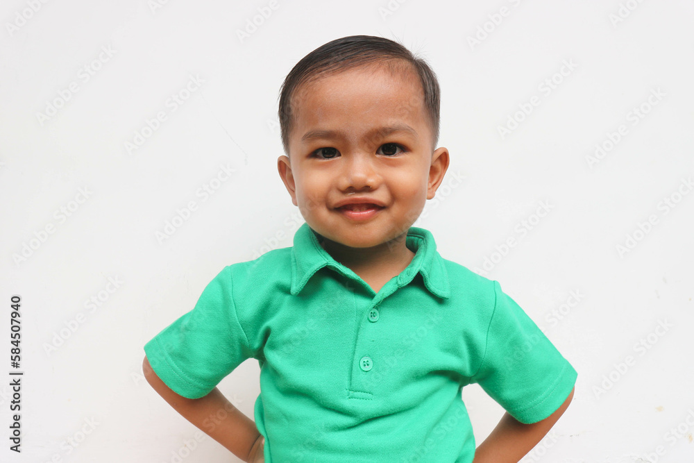 Portrait of a cute little Asian boy standing and smiling while looking at camera, on the white background Portrait of a cute little Asian boy standing and smiling while looking at camera, on the white background