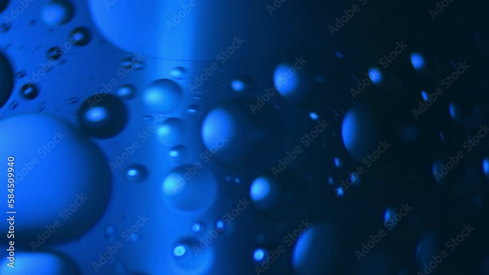 Swirling bubbles of oil in water shot through blue colored jell. Swirling bubbles of oil in water shot through blue colored jell.