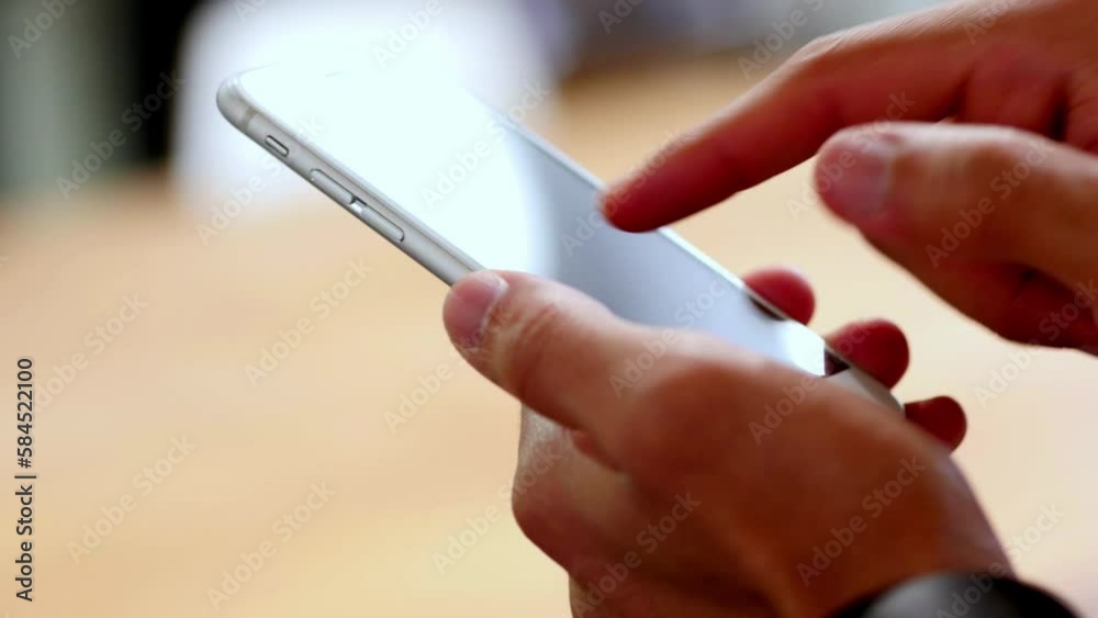 A man's hand seen checking an application on a smartphone - isolated A man's hand seen checking an application on a smartphone - isolated
