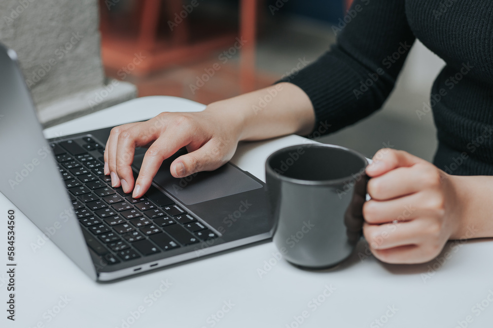 Young Asian woman using smartphone and laptop working remotely at coffee shop. Young Asian woman using smartphone and laptop working remotely at coffee shop.