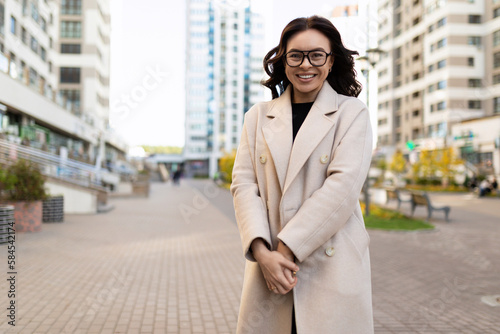 smiling european young woman designer on the background of a city street © Ivan Traimak