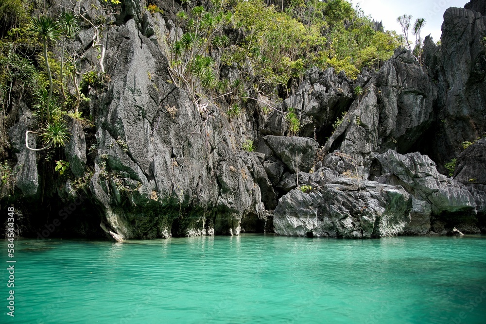 Majestic rocks in El Nido, Palawan in the Philippines that are overgrown with shrubs and rise out of the water.