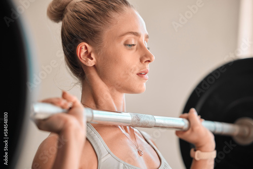 Fitness, bodybuilding and a woman weightlifter in the gym for a workout to build a strong muscular physique. Exercise, weightlifting and a female bodybuilder training her body in a wellness center