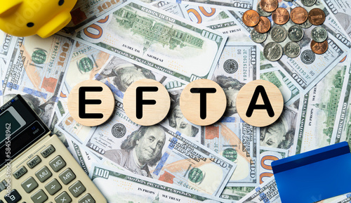 EFTA text in wooden circle on Banknotes background, credit card, piggybank, calculator. European Free Trade Association planning goals, opportunity, Budget, business strategy and financial concept. photo