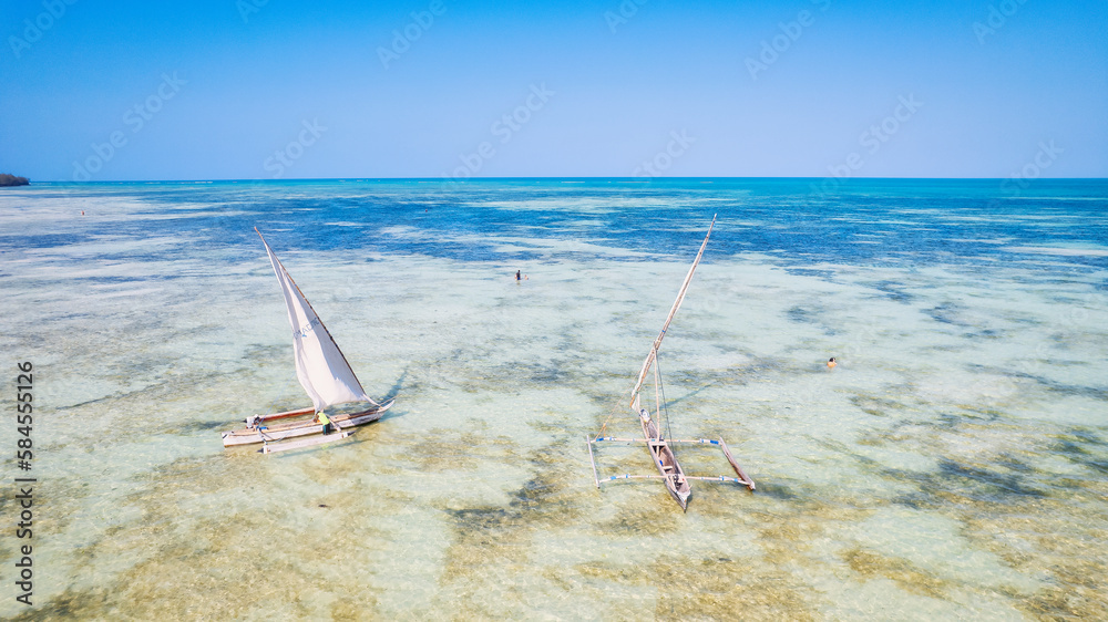 Take in the breathtaking beauty of Zanzibar's tropical coastline from above, as fishing boats dot the sandy beach at sunrise. The view from the top highlights a clear blue sea, green palm trees, Take in the breathtaking beauty of Zanzibar's tropical coastline from above, as fishing boats dot the sandy beach at sunrise. The view from the top highlights a clear blue sea, green palm trees,