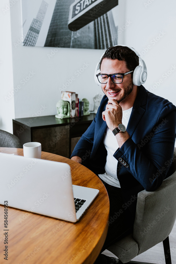 young latin businessman working and using laptop or computer in smart casual clothes at office in Mexico, hispanic people