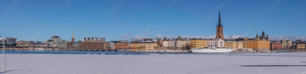 Panorama, down town, court houses, hotel ship at the pier of an old town island at icy bay Riddarfjärden, a sunny spring day in Stockholm