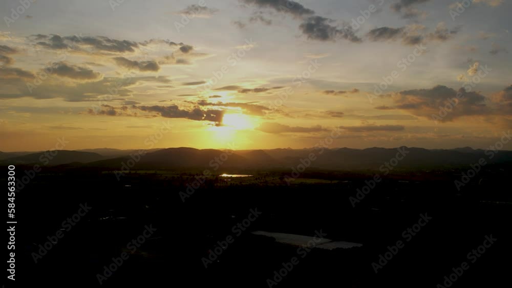 High angle, beautiful sunset over the field, sunrise over the mountains, Dramatic shining yellow in the sky Orange purple cloud sunset sky.