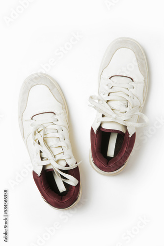 A crisp, clean pair of white leather sneakers isolated on white background, close up studio shot.