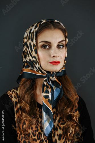 A woman in a scarf on a gray background