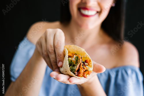 Mexican woman eating tacos al pastor, mexican food in Mexico Latin America	