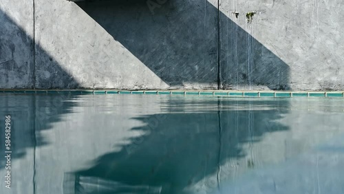 water wave of blue swimming pool on cement wall, construction industry