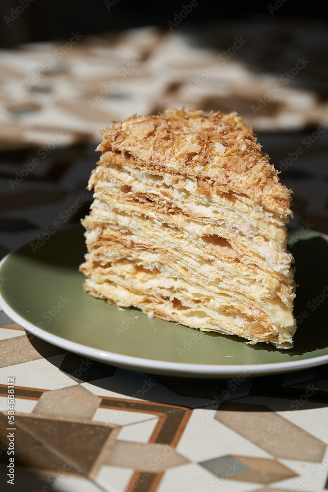 A piece of Napoleon cake on plate, close-up. A piece of Napoleon cake on plate, close-up.