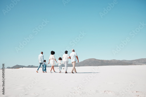 Mother, dad and children with grandparents on beach to relax on summer holiday, vacation and weekend. Happy family, parents and back of kids, grandpa and grandma for walking, bonding and quality time
