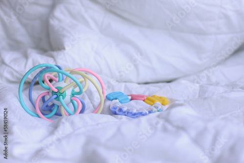Colorful biting toy for baby teeth on the bed
