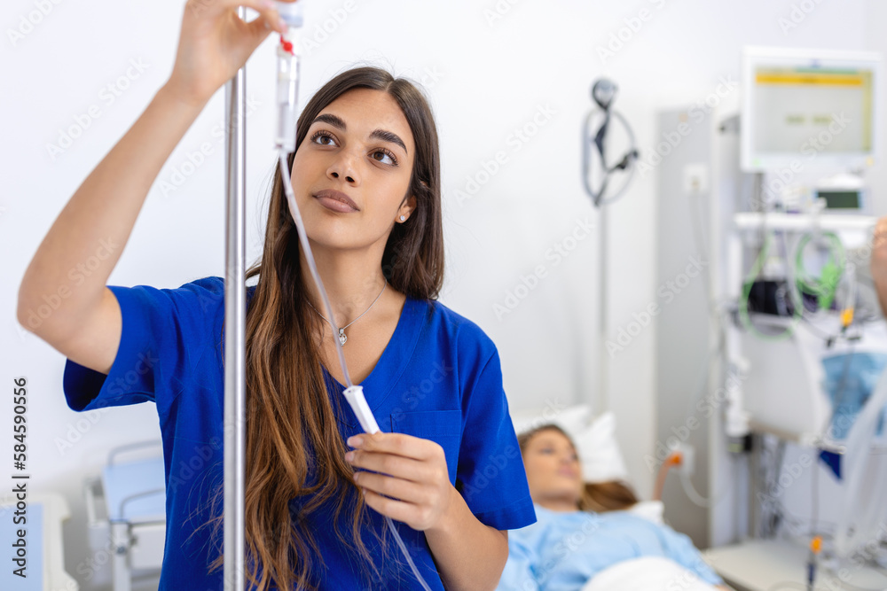 Φωτογραφία Young woman doctor anesthesiologist dressed in blue gown, puts the dropper in ho
