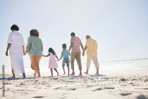 Family, walking on beach sand and holding hands, generations and people, grandparents with parents and kids. Together outdoor, unity and trust, travel to Bali with love, care and bond with back view
