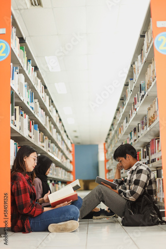 Group of students reading books and preparing to exam in library