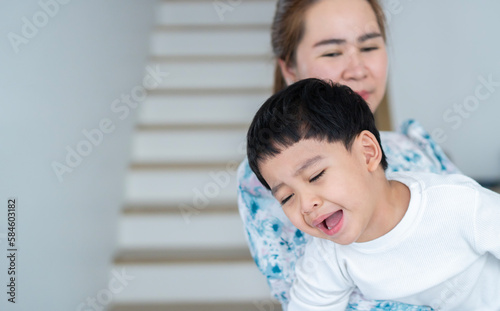 Stubborn little boy scream loud not listening to mom, while loving mother consoling or trying to make a peace.