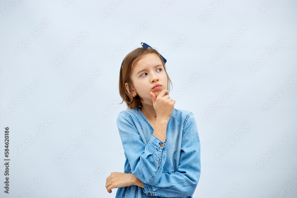 Thoughtful teen girl child wearing jeans dress with finger thinking Thoughtful teen girl child wearing jeans dress with finger thinking