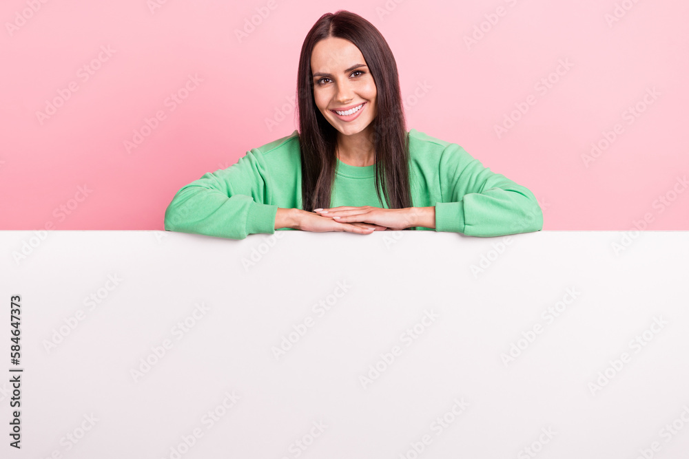 Portrait of optimistic satisfied pretty girl straight hairdo wear green pullover hold hands on placard isolated on pink color background Portrait of optimistic satisfied pretty girl straight hairdo wear green pullover hold hands on placard isolated on pink color background