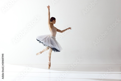 One beautiful ballerina dancing with gracual hands over white background